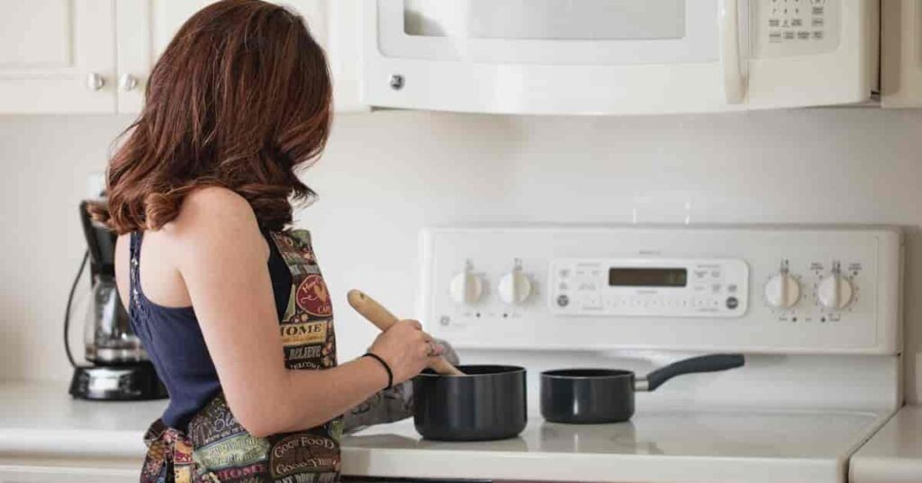 a woman cooking food in pot